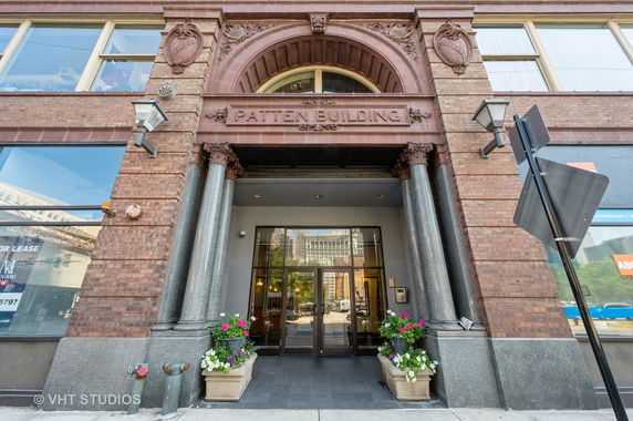 Front view of a historical building entrance with architectural details and large columns.