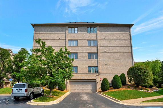 Front view of a multi-story brick building with a garage entrance.
