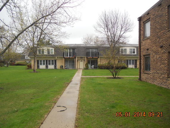 Front view of a two-story residential building with a pathway leading up to it.