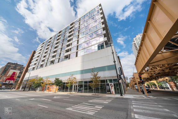 Front view of a multi-story building with large windows on a city street.