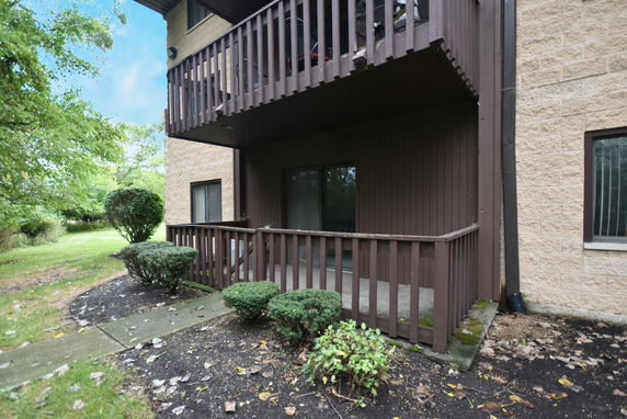 Front view of a building with balconies and a small garden area.