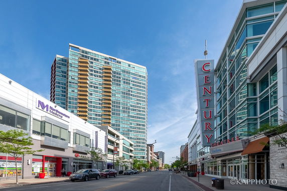 Street view of tall, modern buildings including a theater and a medical center.