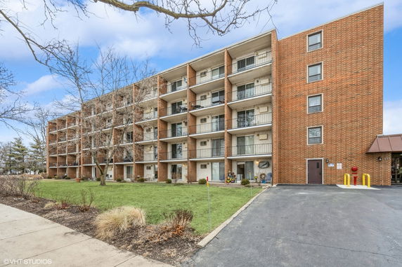 Front view of a multi-story apartment building with balconies.