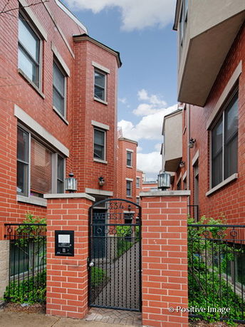 Front view of a brick multi-story building with gated entrance.