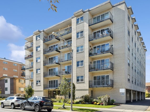Front view of a multi-story apartment building with balconies.