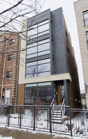 Front view of a modern multi-story building with large windows.