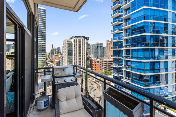 Rooftop view of a city skyline with high-rise buildings and a balcony.