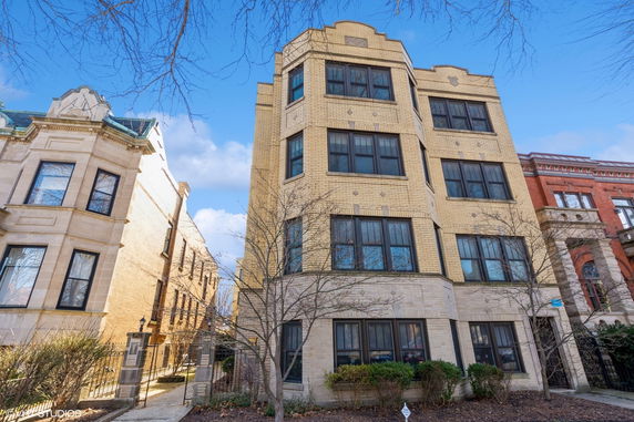 Front view of a multi-story brick building with large windows.