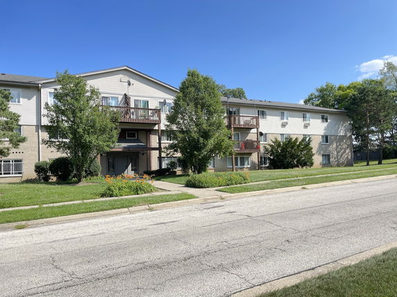 Front view of a multi-story apartment building with balconies.
