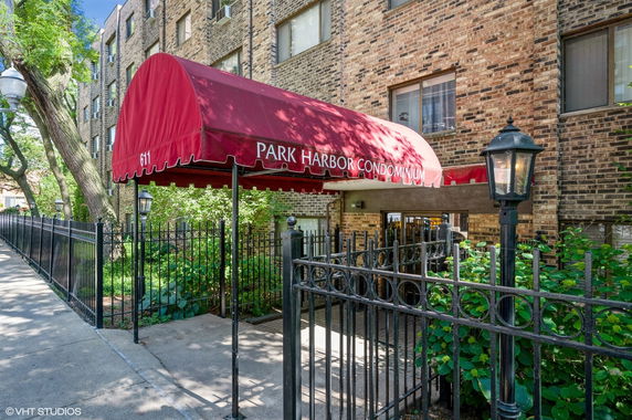 Front view of a condominium building with a red canopy entrance.