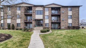 Front view of a multi-story apartment building with brick exterior.