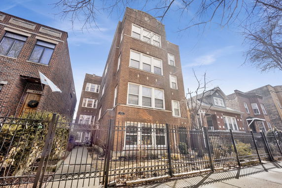 Front view of a multi-story brick apartment building.