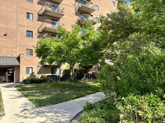 Front view of a multi-story brick apartment building with balconies.