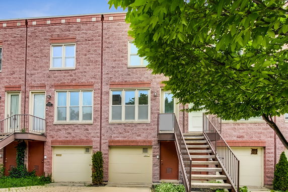 Front view of a townhouse with brick facade and garages.