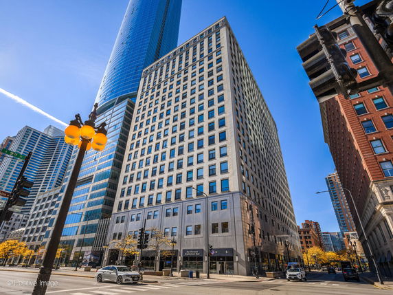 Front view of a multi-story office building located at a city intersection.