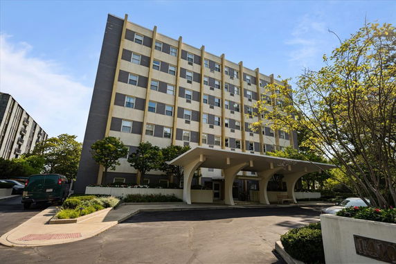 Front view of a multi-story residential building with a covered entrance.