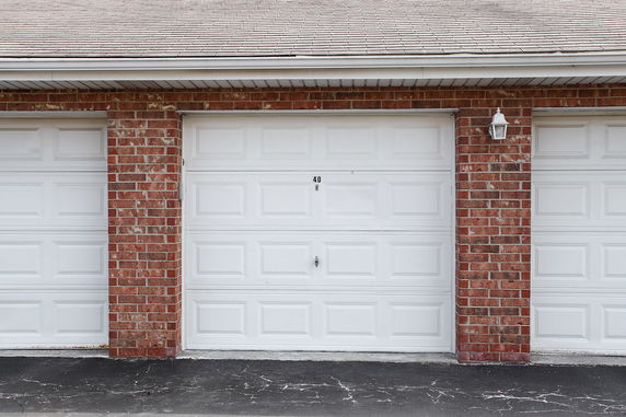 Front view of a garage with brick exterior and white garage door.