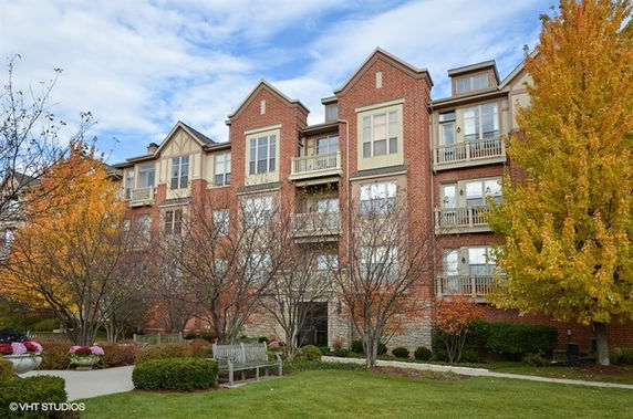 Front view of a multi-story building with brick exterior and balconies.
