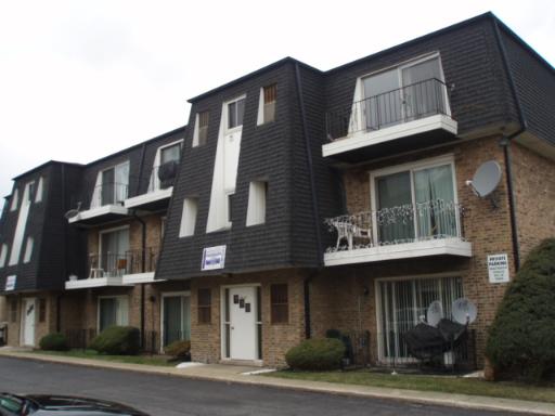 Front view of a three-story apartment building with balconies.