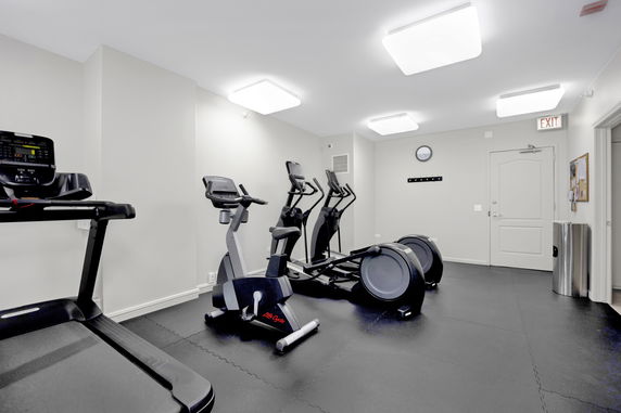 Indoor gym area with exercise equipment including treadmills and stationary bikes.