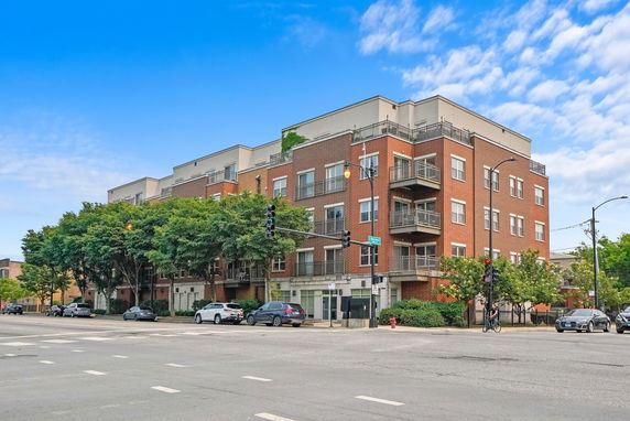 Front view of a multi-story brick apartment building with balconies.