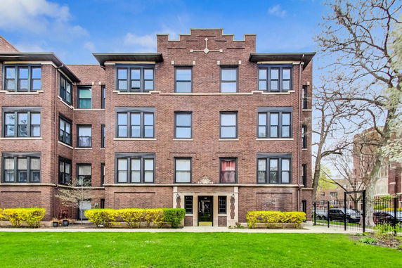 Front view of a multi-story brick apartment building.