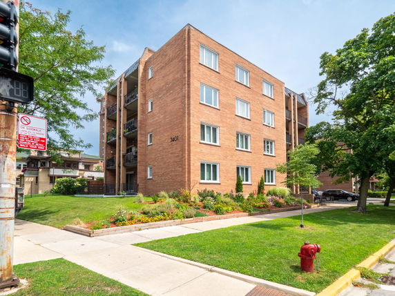 Front view of a multi-story apartment building with brick exterior.
