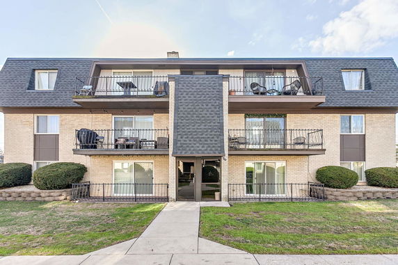 Front view of a multi-story residential building with balconies.