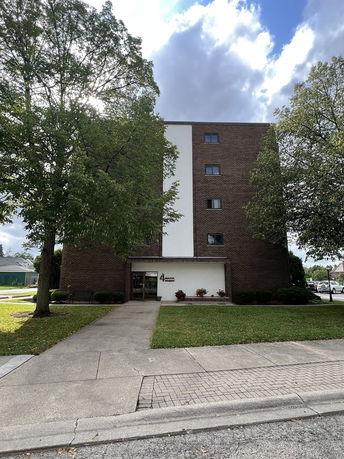 Front view of a multi-story brick building with a central entrance.