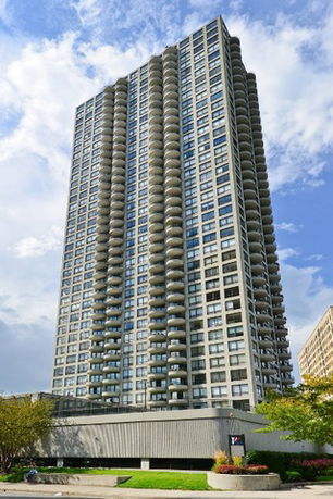 Tall multi-story apartment building with numerous balconies on each floor.
