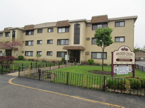 Front view of a three-story condominium building named Brandy Court.
