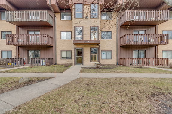 Front view of a multi-story residential building with balconies.