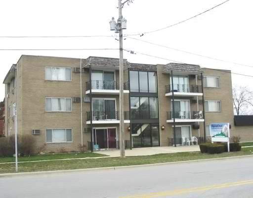Front view of a three-story apartment building with balconies.