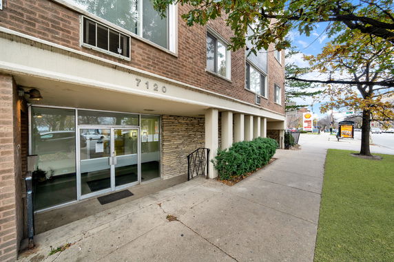 Front view of a multi-story building with brick exterior and glass entrance.