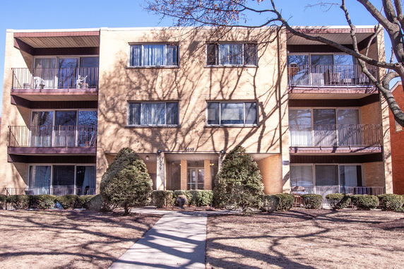 Front view of a three-story apartment building with balconies.