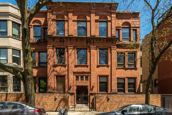Front view of a multi-story brick building with decorative window arches.