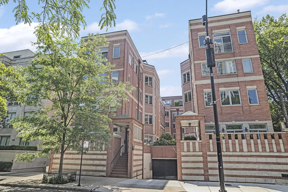 Front view of a multi-story brick building with multiple sections and balconies.
