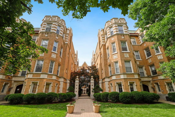 Front view of a brick multi-story building with decorative stone details.