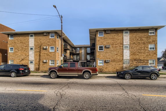 Front view of a multi-story brick apartment building.