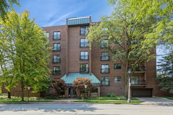Front view of a multi-story brick building with balconies.