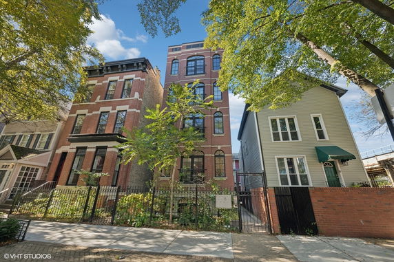 Front view of a multi-story brick building with arched windows.