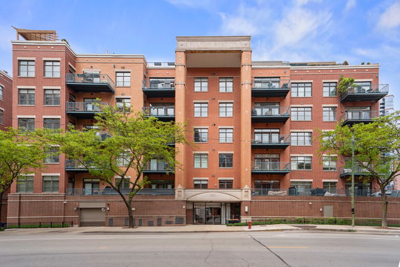 Front view of a multi-story brick building with balconies.