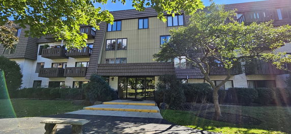 Front view of a multi-story residential building with balconies.