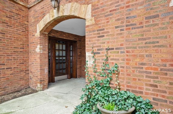 Front view of a building entrance with an arched brick doorway.