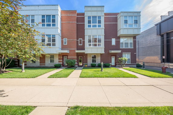 Front view of a multi-story townhouse building with modern design elements.