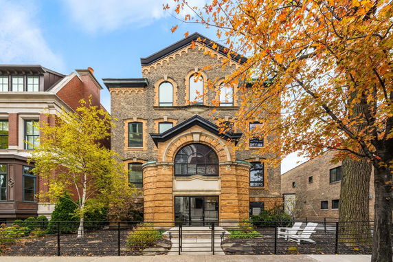 Front view of a multi-story brick building with arched windows and entrance.