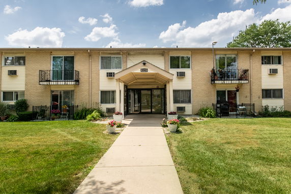 Front view of a multi-story apartment building with balconies.