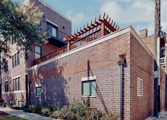 Front view of a brick building with a rooftop deck.