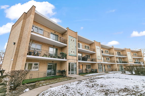 Front view of a multi-story apartment building with balconies.