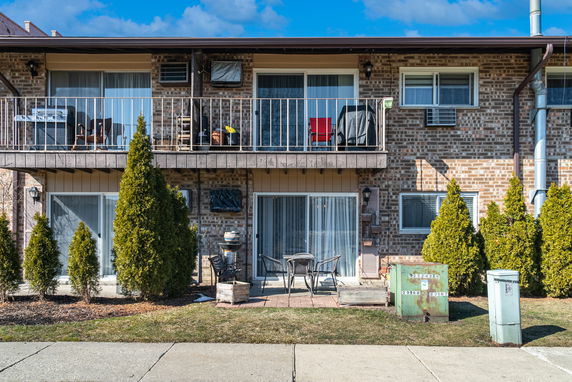 Front view of a two-story brick apartment building with balconies.